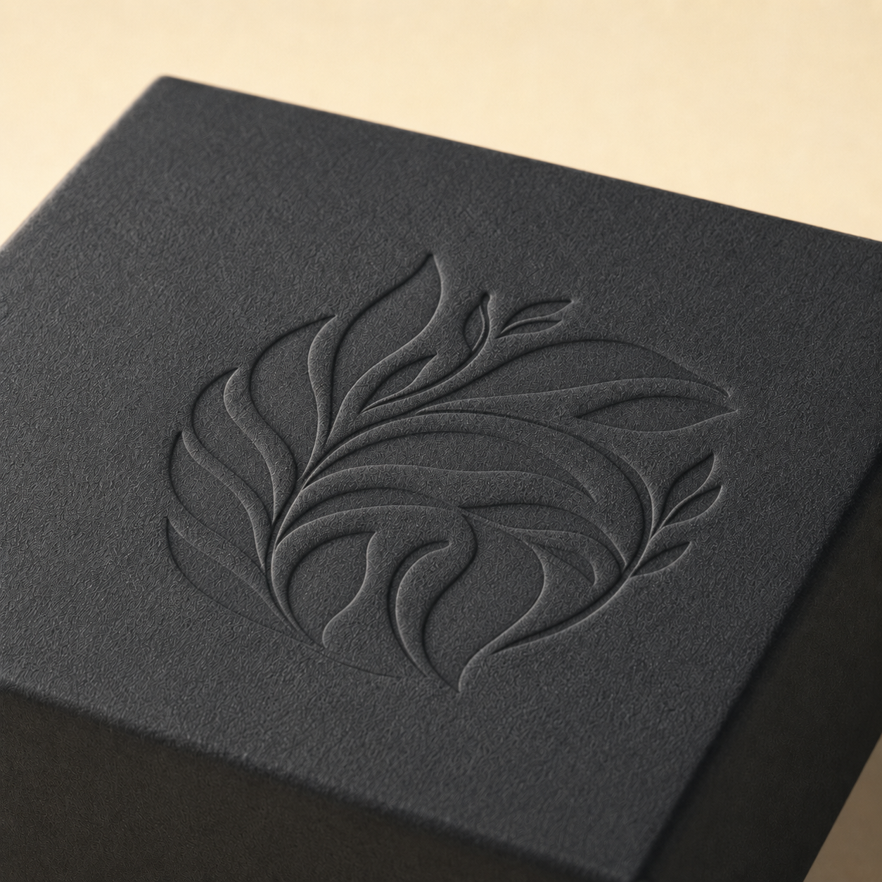 Recessed debossed botanical design on a black custom packaging box.