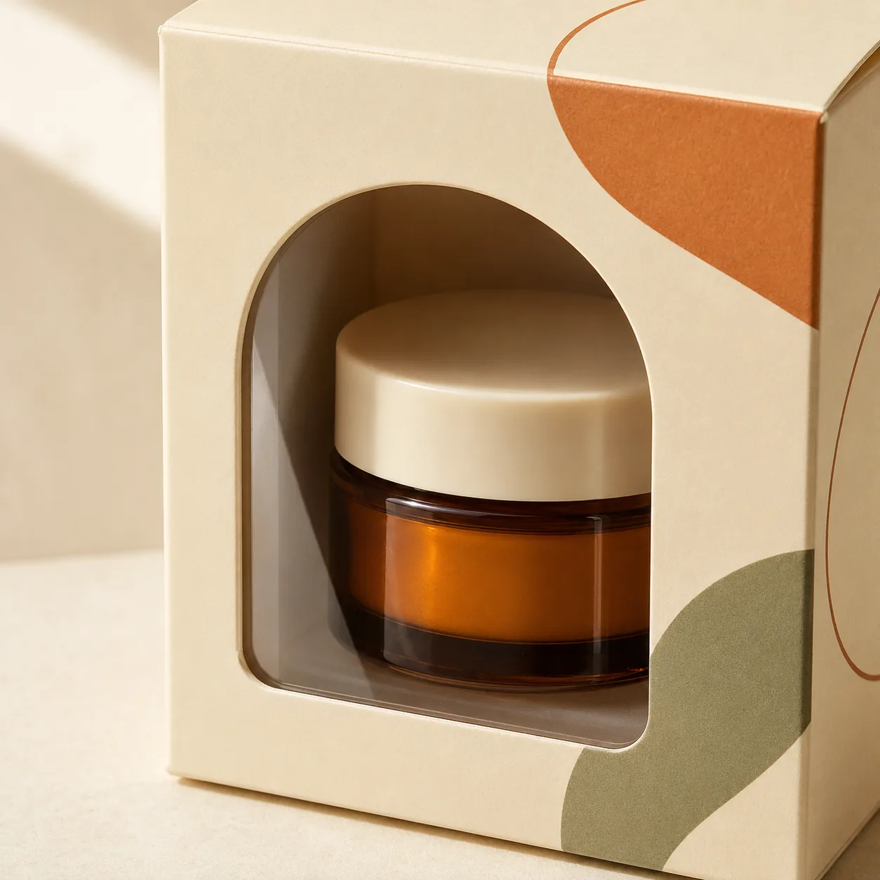 Packaging box with a clear film window displaying an amber cosmetic jar.