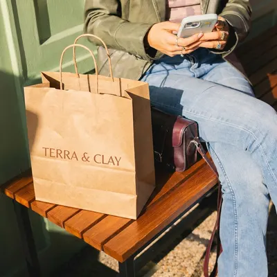 Boutique shopping bag with twisted handles held on a bench