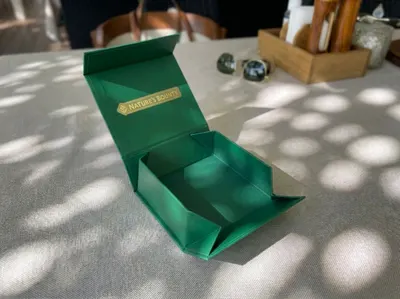 Collapsible rigid box open on an outdoor table