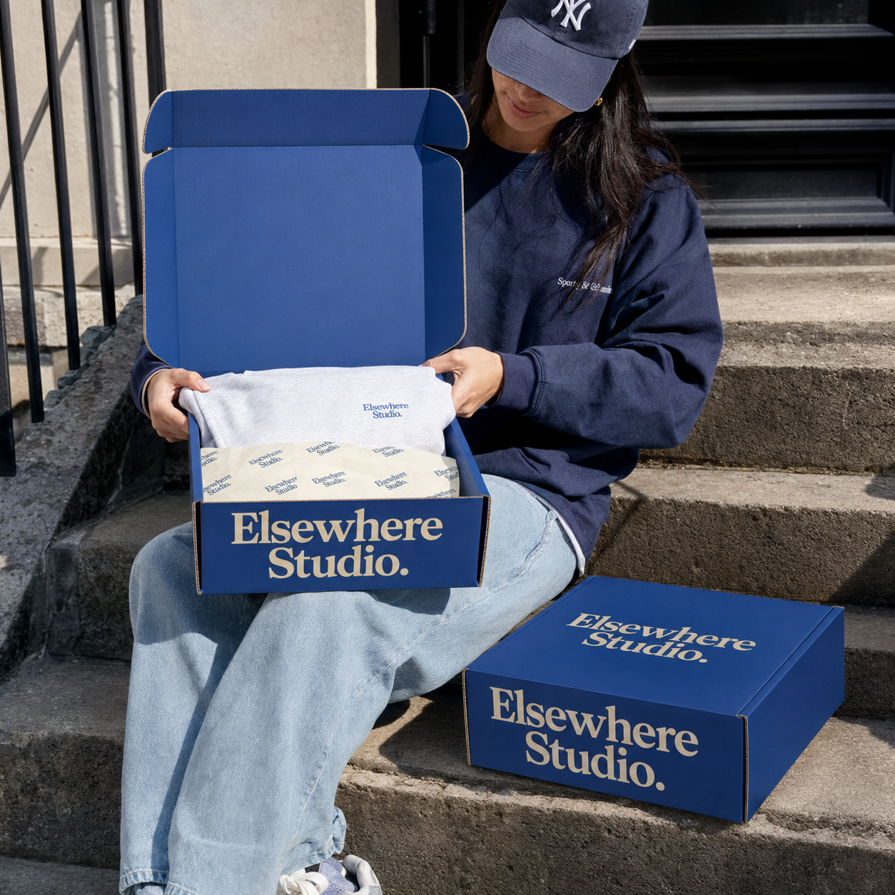 Custom apparel mailer box open showing folded sweatshirt