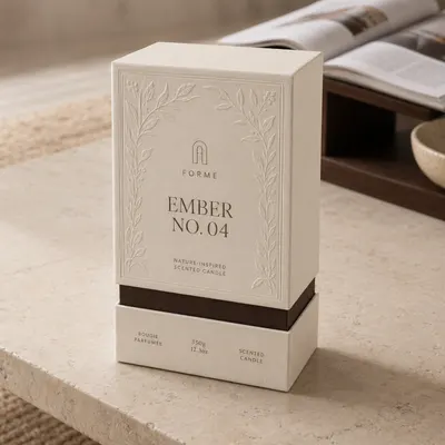 Custom shoulder-neck rigid box in cream with embossed floral border, dark brown accent band, shown closed on a tabletop.