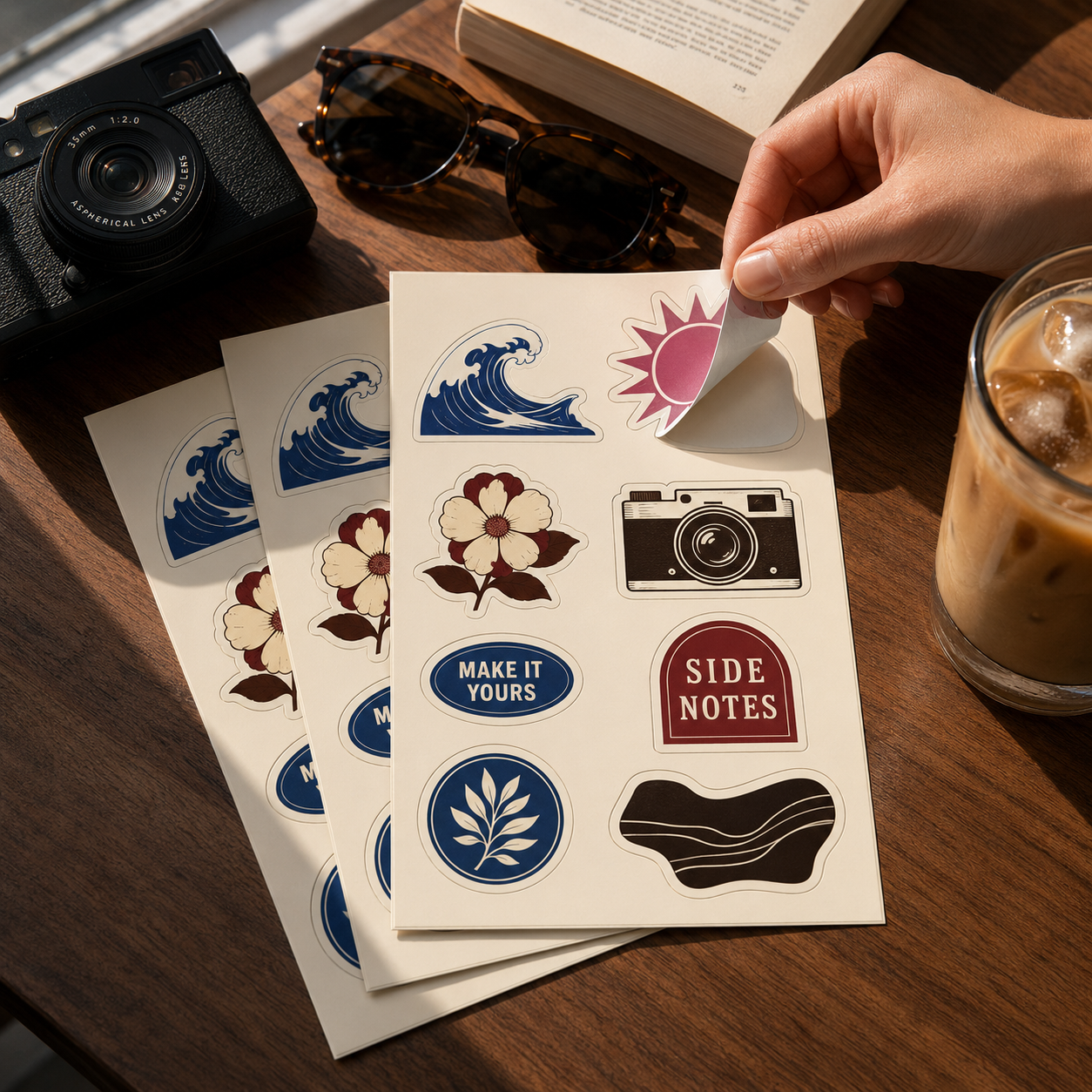 Sticker sheets with assorted designs being peeled on a table